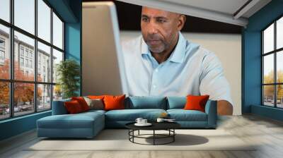 Mature African American man working from his home office. Wall mural