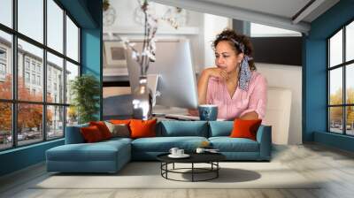 Mixed race woman working from her home office. Wall mural