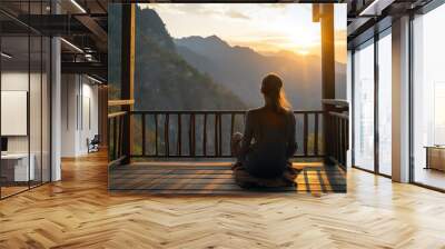 The back of a woman sitting on wooden porch extending into a high mountain cliff Wall mural