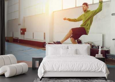 Man slacklining walking and balancing on a rope, slackline in a sports hall Wall mural