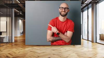 Modern young man pointing with finger on gray copy space Wall mural