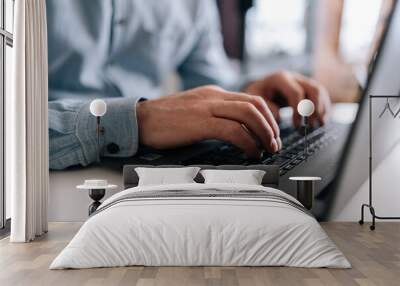 Close-up wrinkly hands of unrecognizable senior older businessman typing on laptop keyboard. Closeup cropped shot of elderly man entrepreneur in home workplace using portable computer sitting at desk. Wall mural