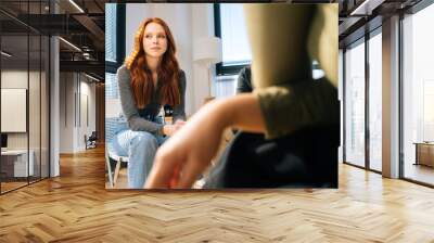 Sad young woman sharing mental problem to other patients sitting in circle during group therapy session. Concept of group consulting of mental health problem with psychologist. Wall mural