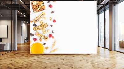 Top view of various homemade granola bars with nuts, seeds, dark chocolate, honey and berries over a white background. Copy space. Wall mural