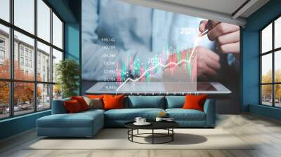 Business investor using mobile tablet to analysis beautiful virtual stock market chart , business analyze by use technology concept. Wall mural