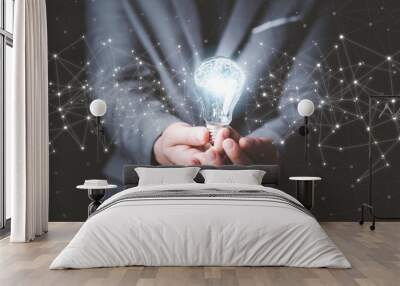 Businessman holding glowing lightbulb with drawing brain and connection line, creative thinking ideas and innovation concept. Wall mural