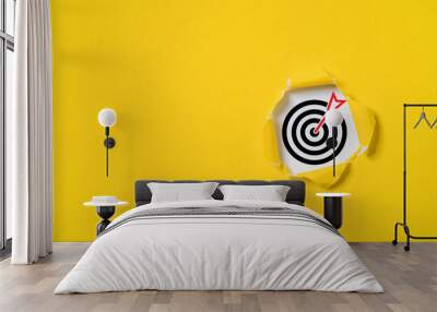 Dartboard with arrow inside of yellow punched paper for setup business objective target and goal concept. Wall mural