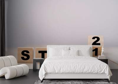 Flipping wooden cubes block for changing step 1 to step 2 on wooden table. Wall mural