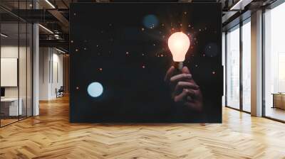 Hand holding glowing lightbulb to creative smart thinking idea for inspiration and innovation concept. Wall mural