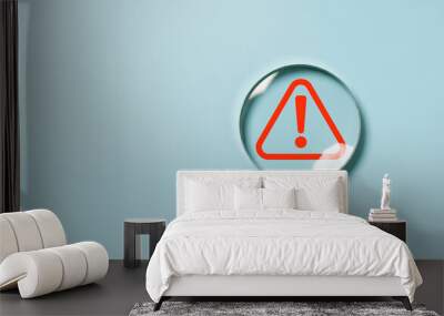 Hand holding magnifier glass with red triangle caution warning sign for focus notification error and maintenance concept. Wall mural