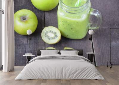 Green healthy smoothie in glass jar: banana, kiwi, green apple on rustic background Wall mural