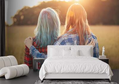 Two young women standing on the background of sunset. Best friends Wall mural