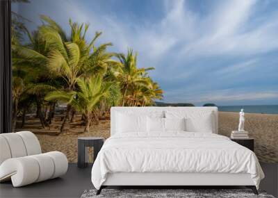 Lots of palm trees on a sandy beach with sunset light. Summer and travel concept Wall mural