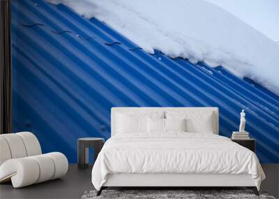 snow on a blue roof. Snow snow falls from the roof. spring is melting snow Wall mural