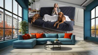 Upset woman struggle with autumn depression, loneliness and mental disorder stay at home in company of two dogs sit alone on sofa drink tea. Depressed bipolar female avoid people and social contact Wall mural