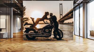 Evening walk of a biker and a girl on the river bank. Photoshoot at sunset. Wall mural