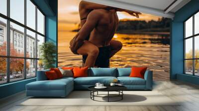 Romantic photo session in the water. A guy and a girl swim in the lake in the evening. Beautiful sunset. Wall mural