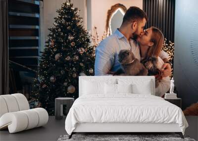 The guy and the girl celebrate the New Year. A married couple retired in a cozy studio setting. In her arms is a small dog and a gray cat. Wall mural