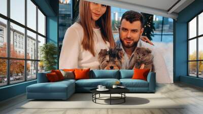 The guy and the girl celebrate the New Year. A married couple retired in a cozy studio setting. In her arms is a small dog and a gray cat. Wall mural