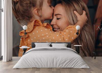 Young mother with her little daughter. Maternal love for a child. Studio photography. Wall mural