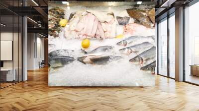 seafood on display in ice, crayfish, various fish, lemon Wall mural