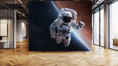 Astronaut float in outer space over of the planet Mars on the background. Elements of this image furnished by NASA Wall mural