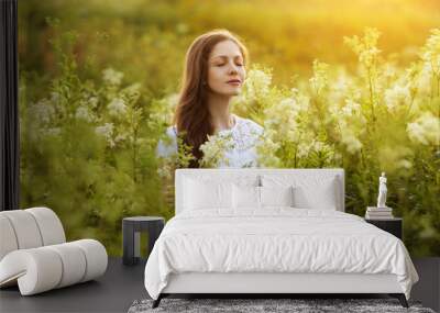 Happy beautiful girl stands among wildflowers Wall mural