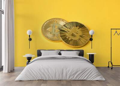 Two gold coins bitcoin on a yellow background Wall mural