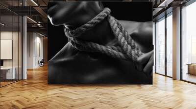 A young woman plucks ropes from her body and neck. Photo in black and white Wall mural