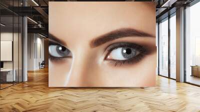 Beautiful Woman with long lashes and beautiful make-up looking at the camera. Wall mural