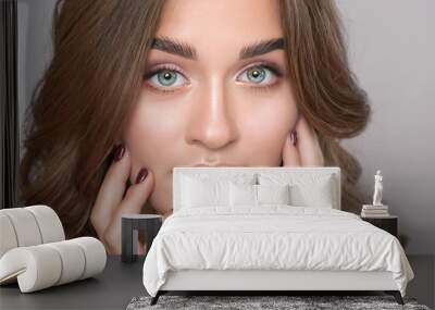 Portrait of a beautiful happy woman with long eyelashes, beautiful fresh nude make-up, thick eyebrows and with clean skin in a beauty salon. Eyelash extensions. Face close-up. Make-up concept Wall mural