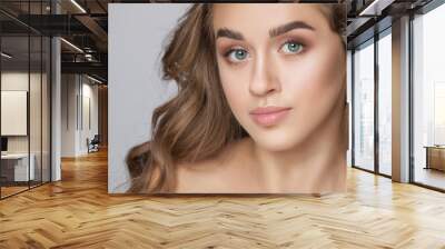 Portrait of a beautiful woman with long eyelashes, beautiful fresh nude make-up, thick eyebrows and with clean skin in a beauty salon. Eyelash extensions. Face close-up.Make-up and cosmetology concept Wall mural