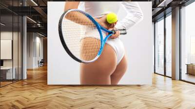 Slender woman in white bodysuit  plays tennis. The concept of sports and healthy lifestyle. Wall mural