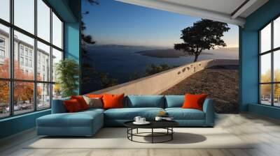 Beautiful big terrace with trees and  a breathtaking view over the volcano and the aegean sea in Santorini Greece Wall mural