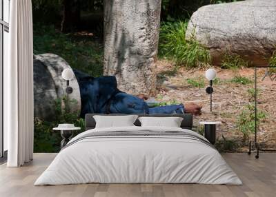 Athens, Greece, April 2020: Homeless man laying sleeping amongst ancient Greek columns Wall mural