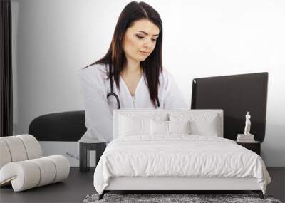 beautiful woman doctor sitting at the table and working on a lap Wall mural