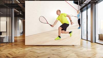 young caucasian man and woman playing squash. Wall mural