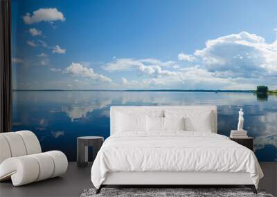 Panorama of calm lake, Kama river blue sky with clouds reflected in the water. Wall mural