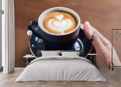 A cup of cappuccino in a hand Wall mural