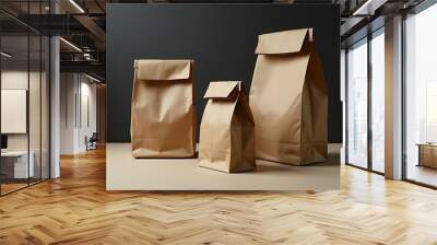 Brown paper bags of different sizes stand upright on a dark background, perfect for packaging, food delivery, and eco-friendly storage solutions. Wall mural