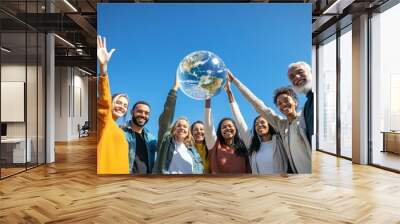 group of diverse people holding up  transparent globe, standing together outdoors with a clear blue sky in the background, symbolizing unity in preserving the ozone layer environment Wall mural