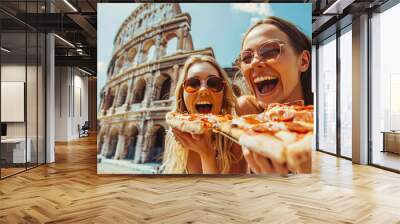 Two beautiful young women having fun and eating pizza at Coliseum in Rome. Italian cuisine, restaurant menu. Happy friends tourists enjoying italian pizza. Summer vacation, travel, gastronomic journey Wall mural