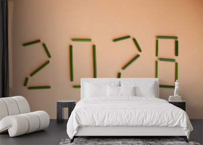 Year twenty twenty eight or two thousand twenty eight shaped with green plant on beige background Wall mural