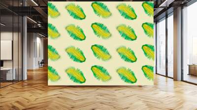 Yellow and green feathers isolated on yellow background. Pattern Wall mural