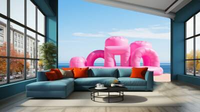 Big Inflatable Pink bounce castle on a sandy beach against blue sky, minimal style summer wallpaper, nobody. Sea beach vacation, fun activity for kids. Wall mural