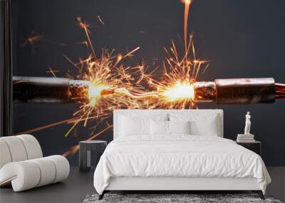 Electric Spark Between Two Bare Wires. A captivating close-up of electric spark igniting between twisted bare copper wires on a simple grey background with copy space. Wall mural