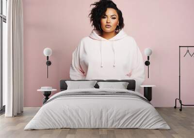 Full body portrait of plus size model woman wearing sport hoody on flat pink background, copy space. Store sportswear of all sizes, bodypositive.  Wall mural