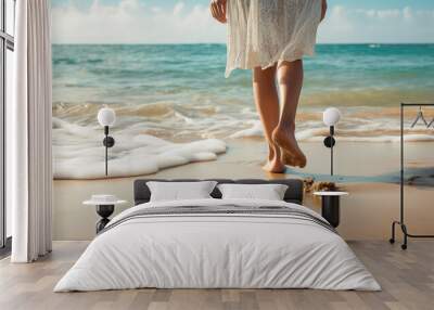 Wet shoreline sand with barefoot prints. Closeup back view photograph woman legs walking barefoot along a beautiful beach.  Wall mural