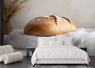 White fresh puffy loaf of bread on white textile on white background. Light pastel colors, hot freshly baked bread.  Wall mural