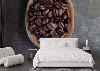 Coffee beans in a wooden spoon with stone background. Wall mural